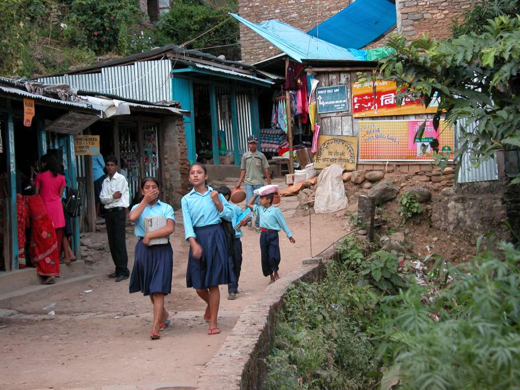 Manaslu 01 08 Arughat School Children We waited over an hour for the porters at Arughat. I passed the time by watching the blue-uniformed school children walk past. I'd just stare at them, and then just as they passed I'd break into a smile, and so would they.